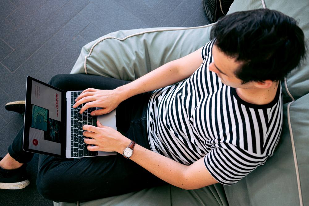 Man in striped t-shirt on laptop
