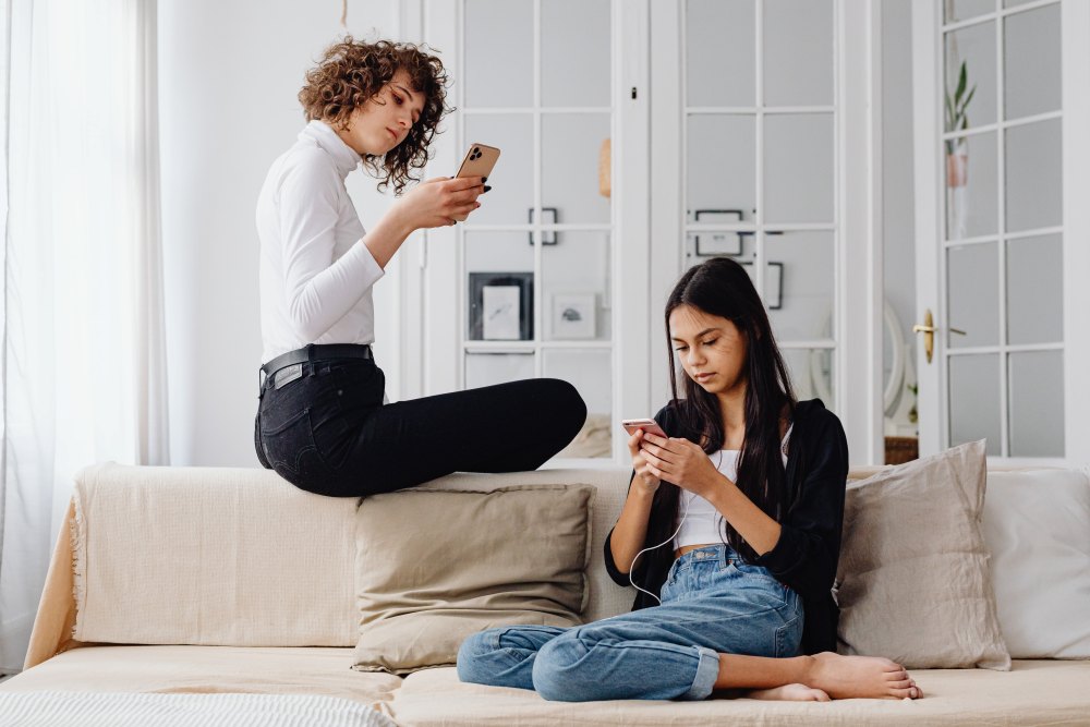 Two women sitting on couch looking at Instagram
