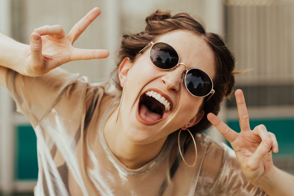 Girl in sunglasses showing peace signs