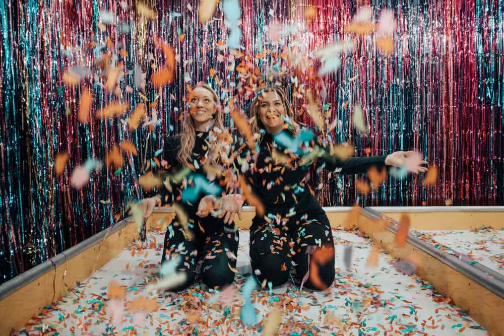 Two women celebrating with confetti
