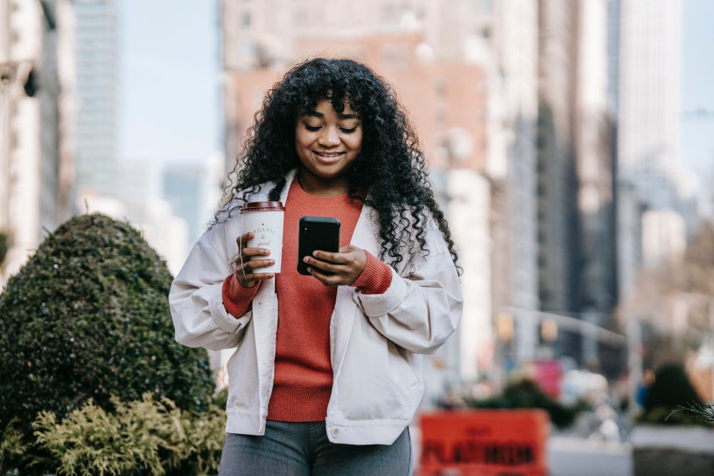 Woman holding coffee and phone
